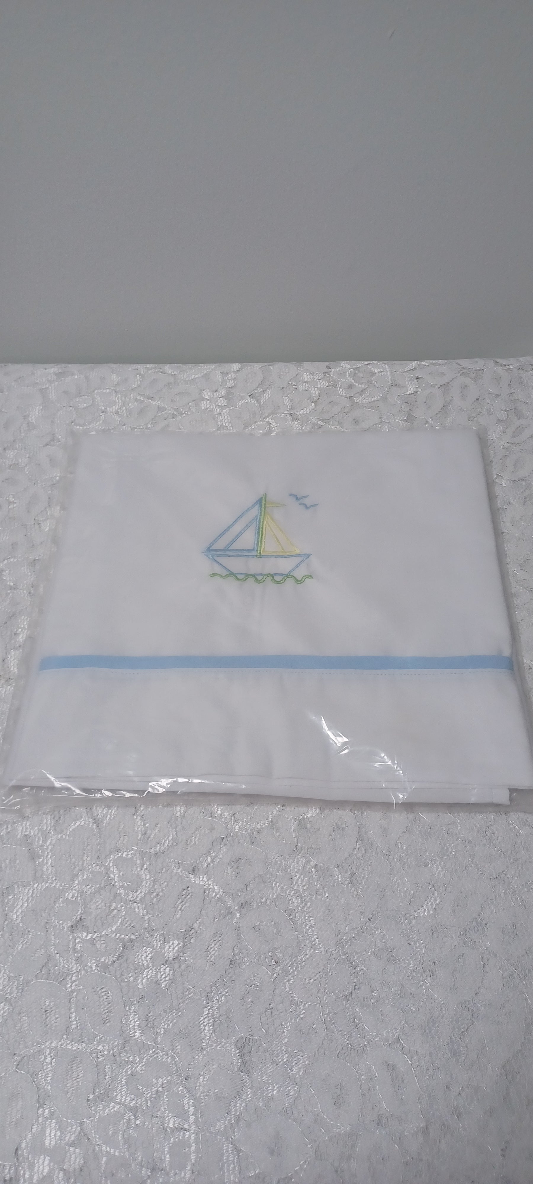 White Blanket With Embroidery Sailboat And Blue Trim